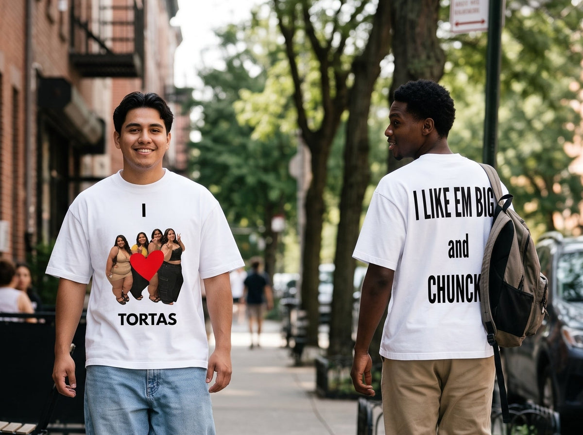 Two men walking on a city sidewalk wearing matching white graphic T-shirts. The man on the left faces forward with a graphic showing the cast of 'The Office' and the text 'I [heart] TORTAS'.